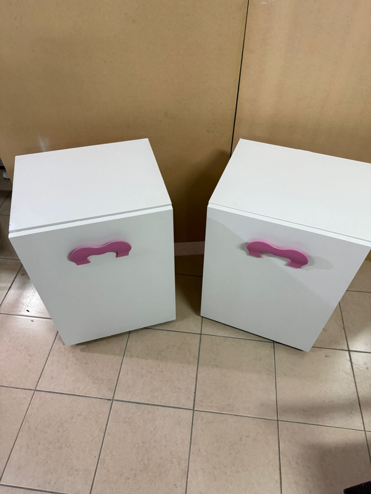 A white children's study desk with pink handles, featuring a foldable