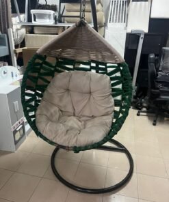 A "bird's nest" design swing chair made from handwoven materials with comfortable cushions.