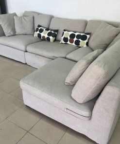 Light beige corner sofa, with a comfortable design and extra cushions.