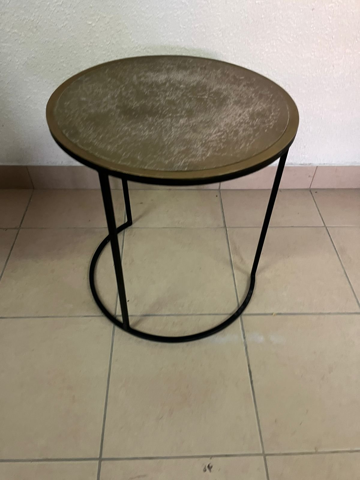 Round metal side table with a copper top