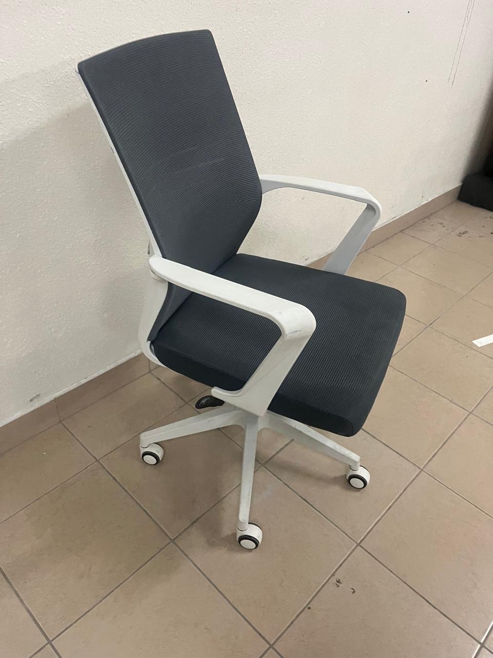 A gray office chair with a white frame and mesh back design.