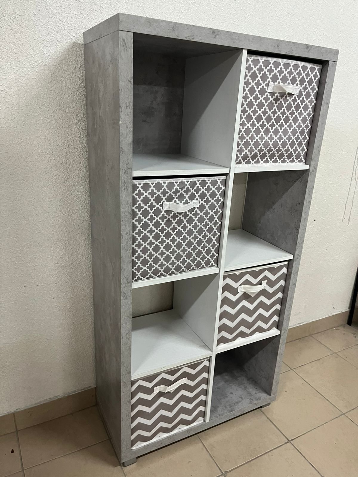 This gray wooden storage unit from Home Source features fold-down fabric drawers.