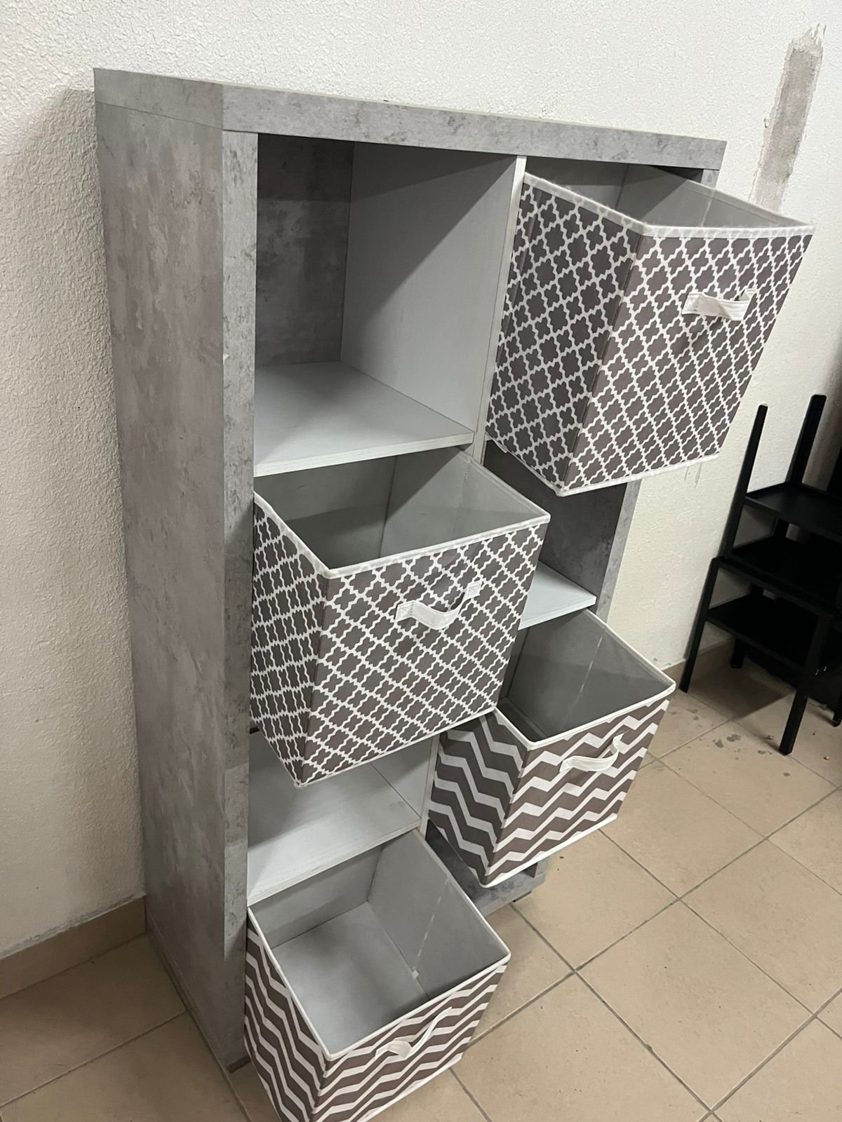 This gray wooden storage unit from Home Source features fold-down fabric drawers. - Image 10