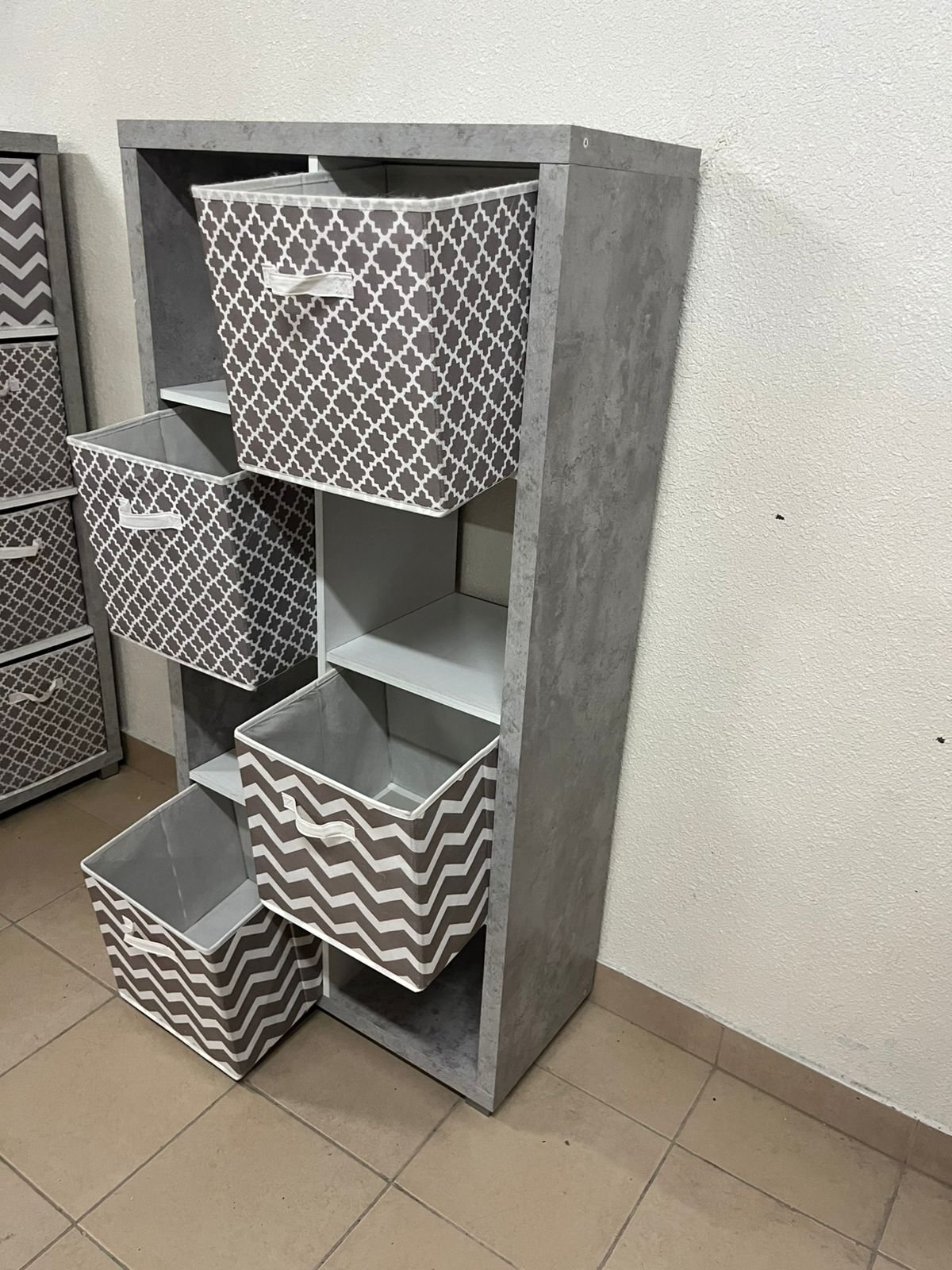This gray wooden storage unit from Home Source features fold-down fabric drawers. - Image 11