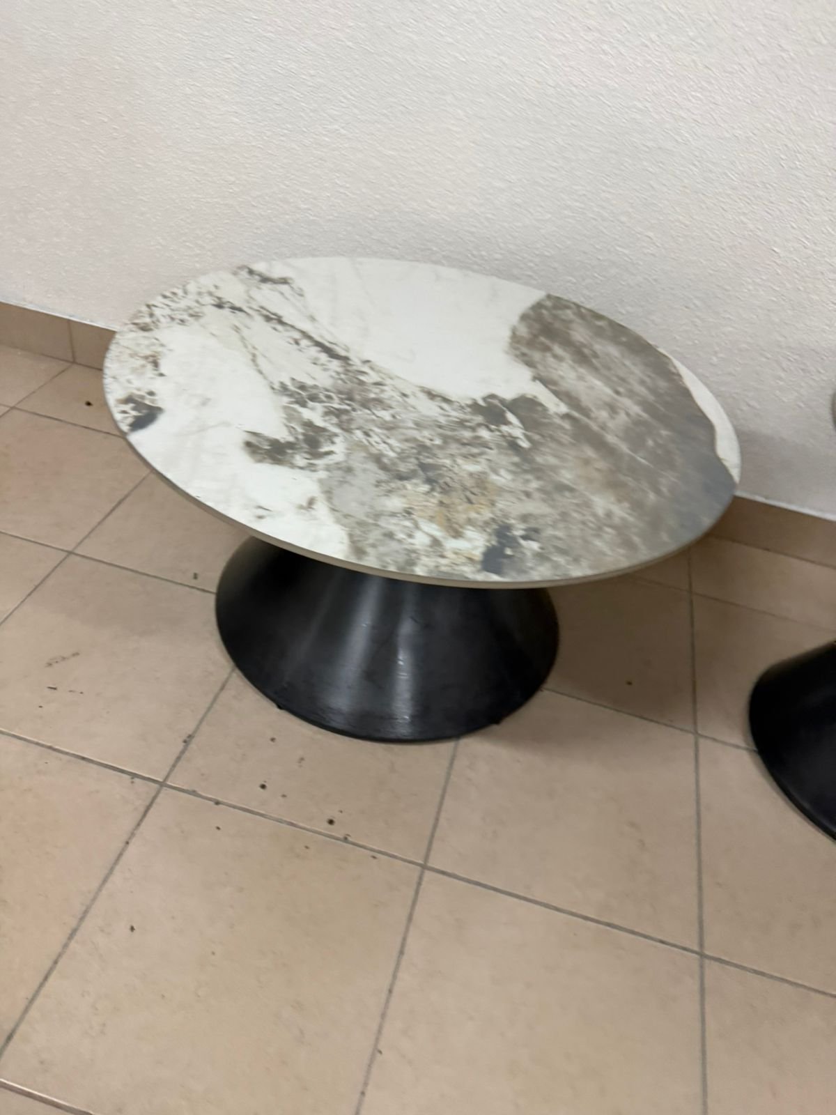 This is a round coffee table with a marble top and a black metal base in a modern design. - Image 7