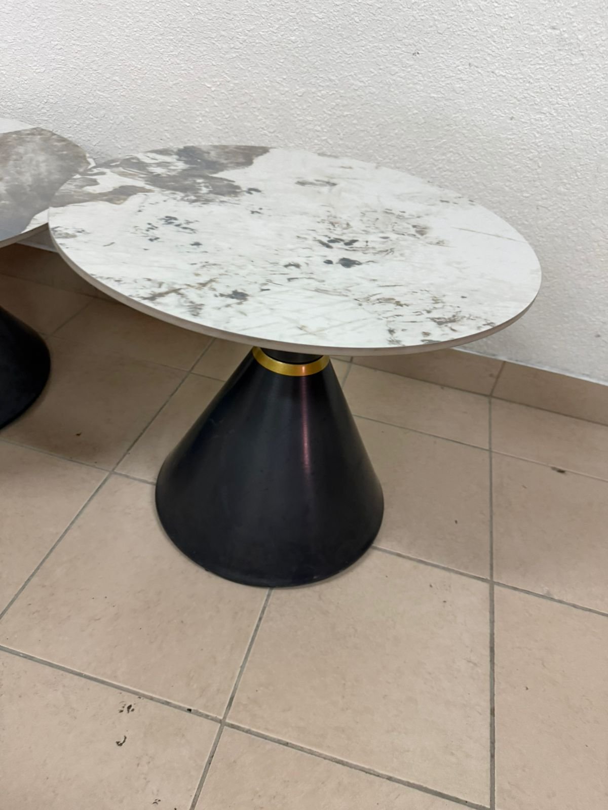 This is a round coffee table with a marble top and a black metal base in a modern design. - Image 12