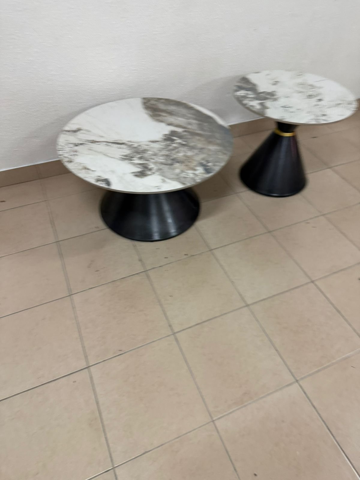 This is a round coffee table with a marble top and a black metal base in a modern design. - Image 15