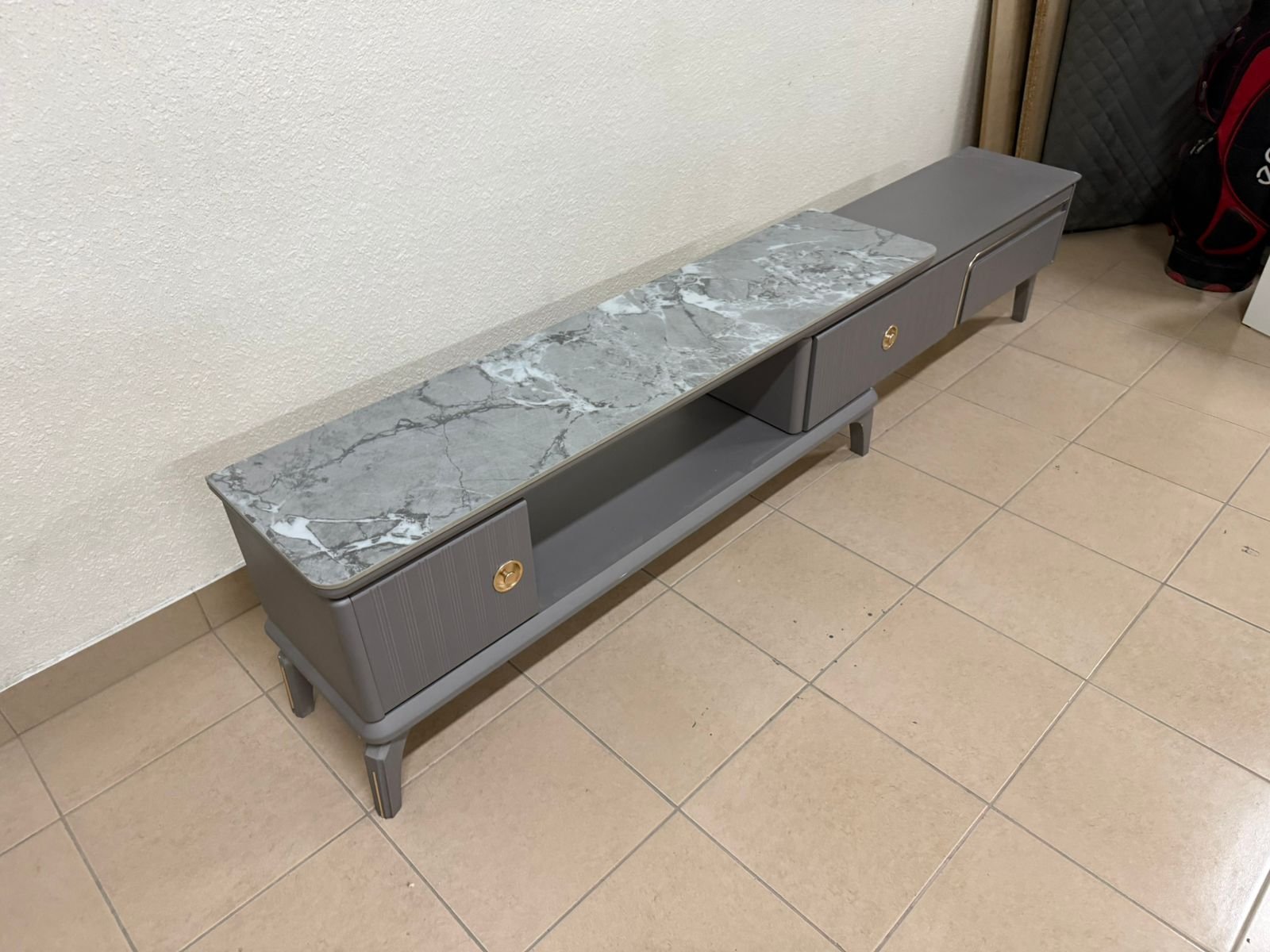 Modern gray extendable TV table with a marble top.