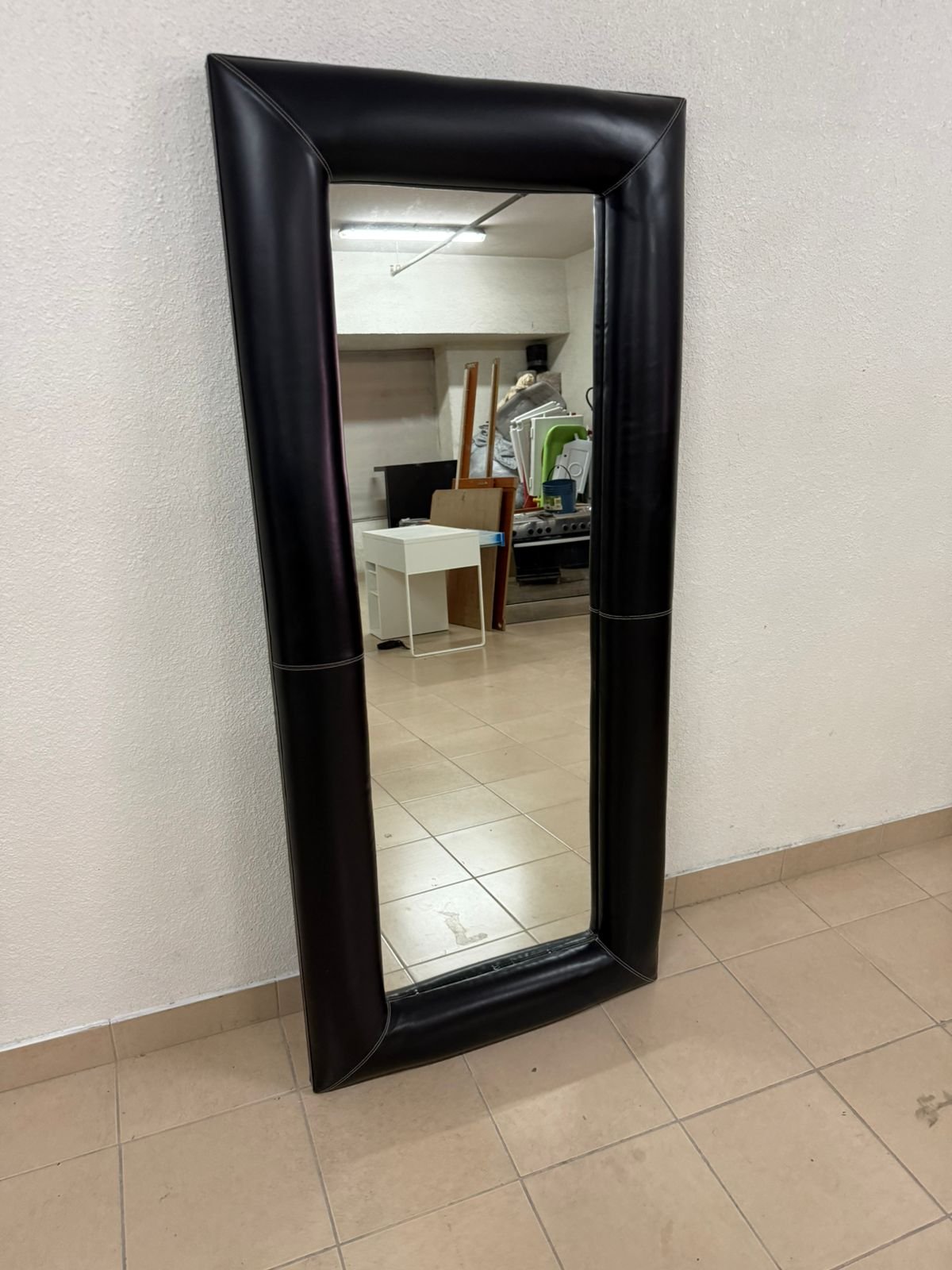 Full-length floor mirror with a black, quilted leather frame