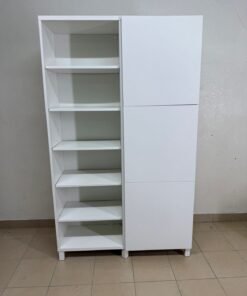 A white storage cabinet from IKEA, model BESTÅ, comes with open units and closed fronts.