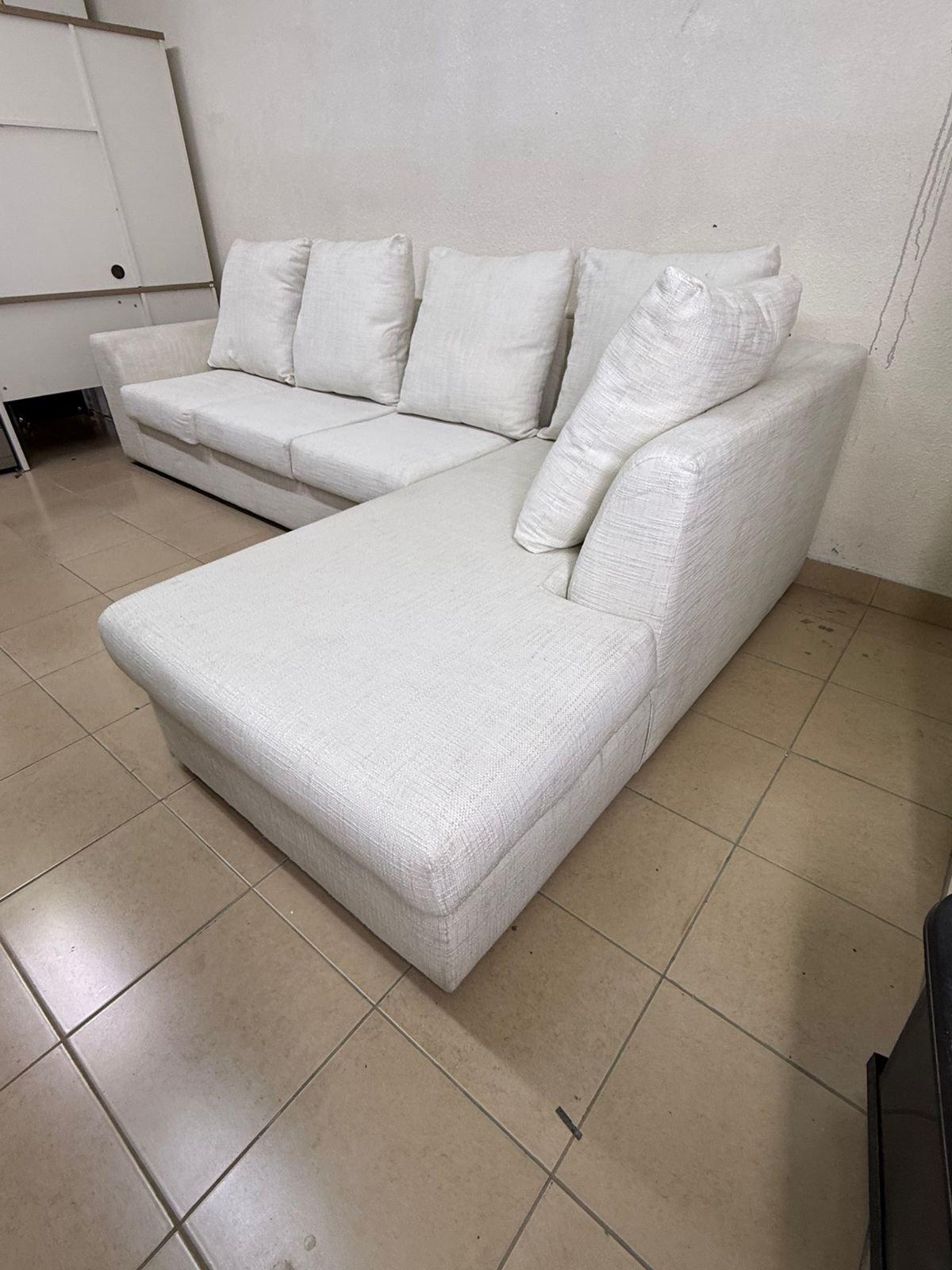 Light-colored sectional (L-shaped) sofa with comfortable back cushions