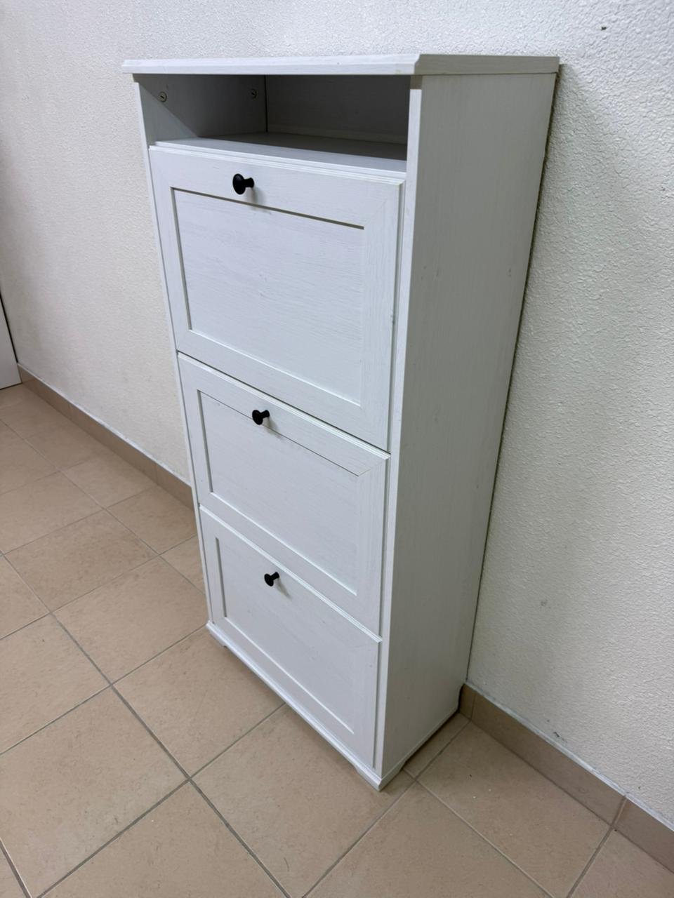White shoe cabinet with flip-up drawers and small black handles