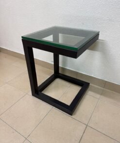A modern side table featuring a geometric black metal frame and a glass top.
