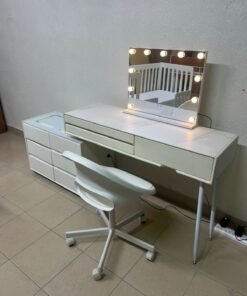 A modern white vanity table with an LED mirror, wireless charger, Bluetooth speaker, and matching chair.
