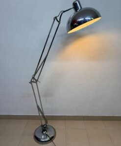 A chrome floor lamp with an industrial design reminiscent of the iconic "Anglepoise" lamp.