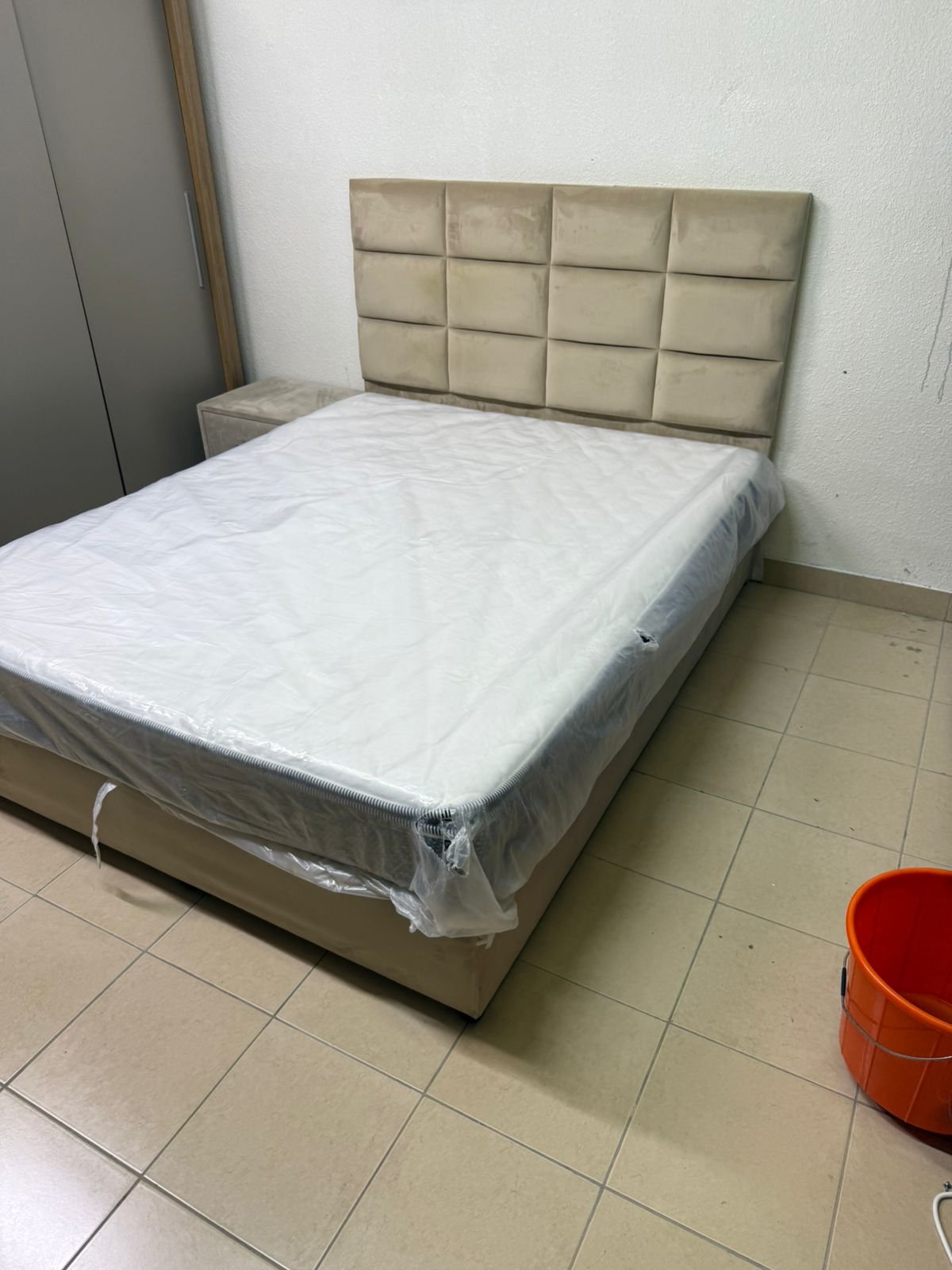 The beige upholstered bed features a checkered, padded headboard and comes with a new mattress. - Image 11