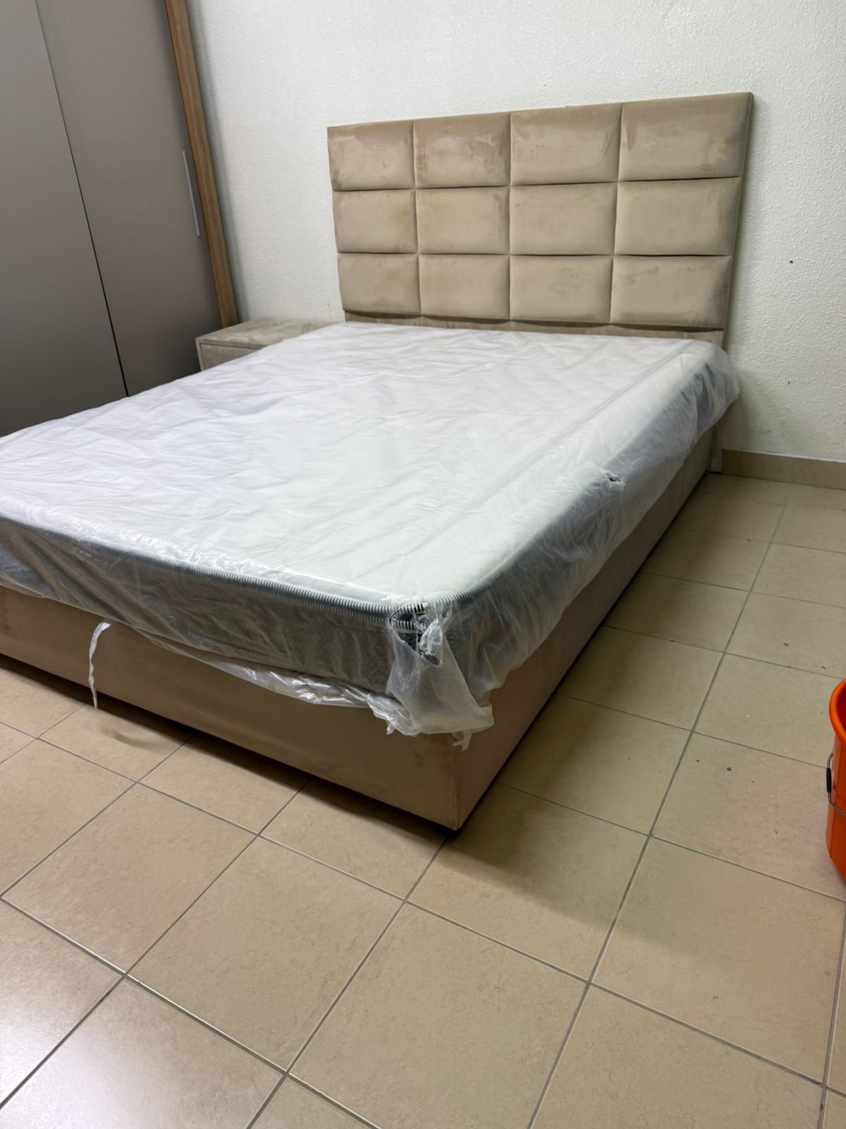 The beige upholstered bed features a checkered, padded headboard and comes with a new mattress. - Image 12