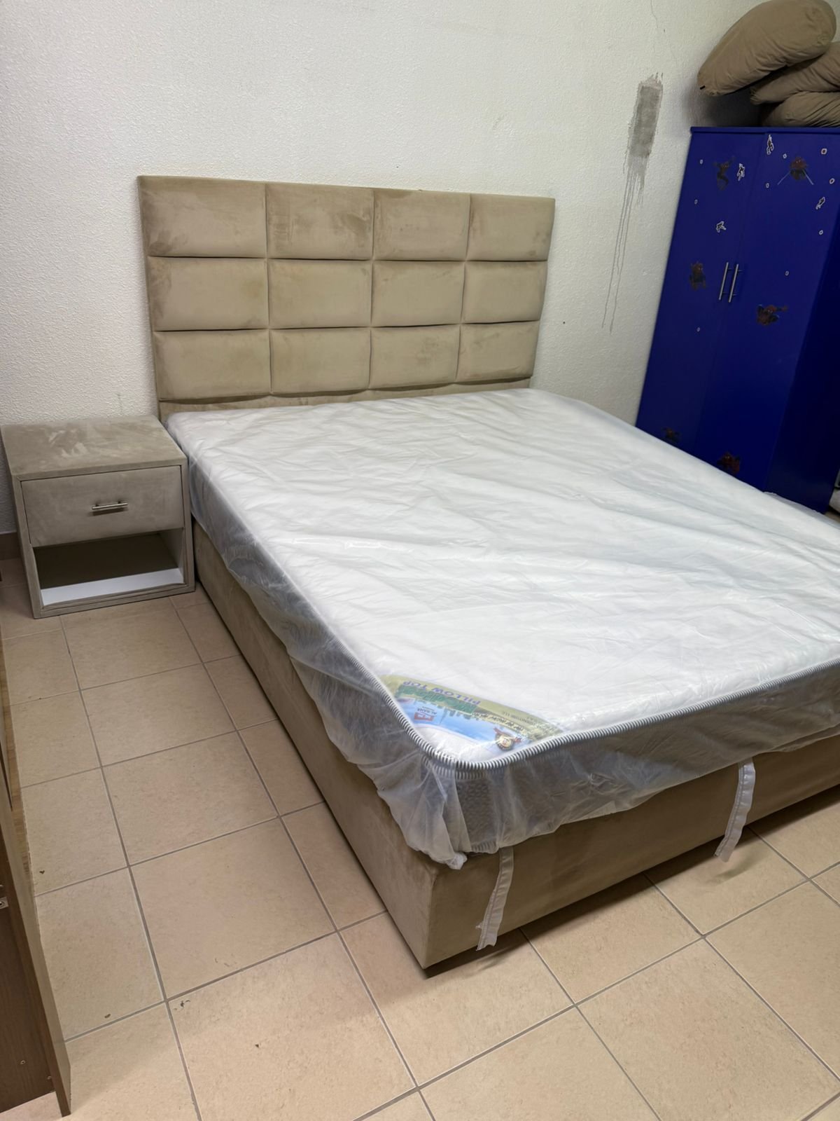 The beige upholstered bed features a checkered, padded headboard and comes with a new mattress. - Image 10