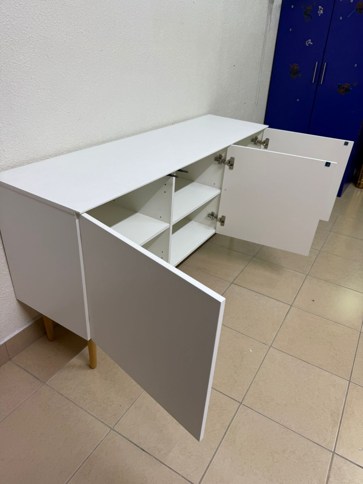 A modern white buffet cabinet featuring a simple design and light-colored wooden legs. - Image 9