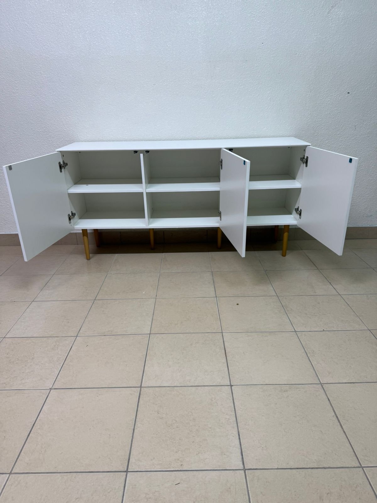 A modern white buffet cabinet featuring a simple design and light-colored wooden legs. - Image 8