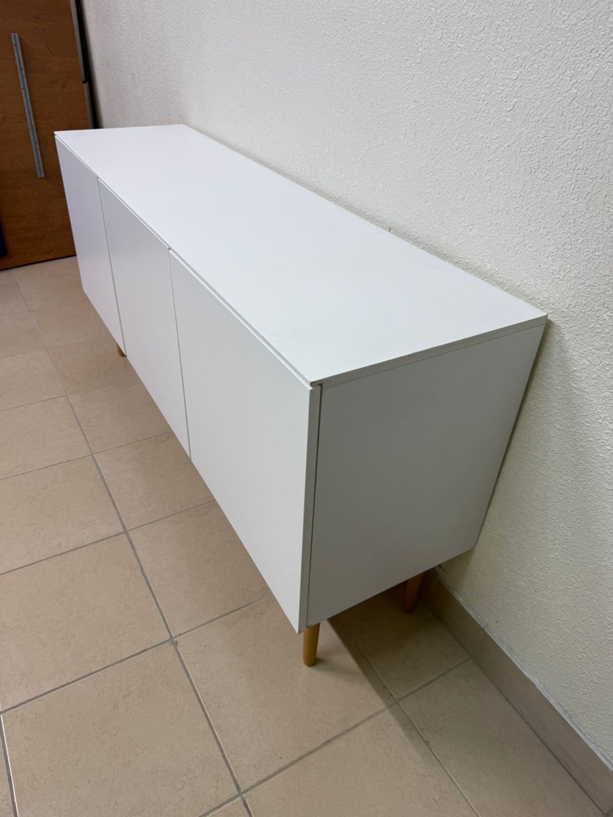 A modern white buffet cabinet featuring a simple design and light-colored wooden legs. - Image 7