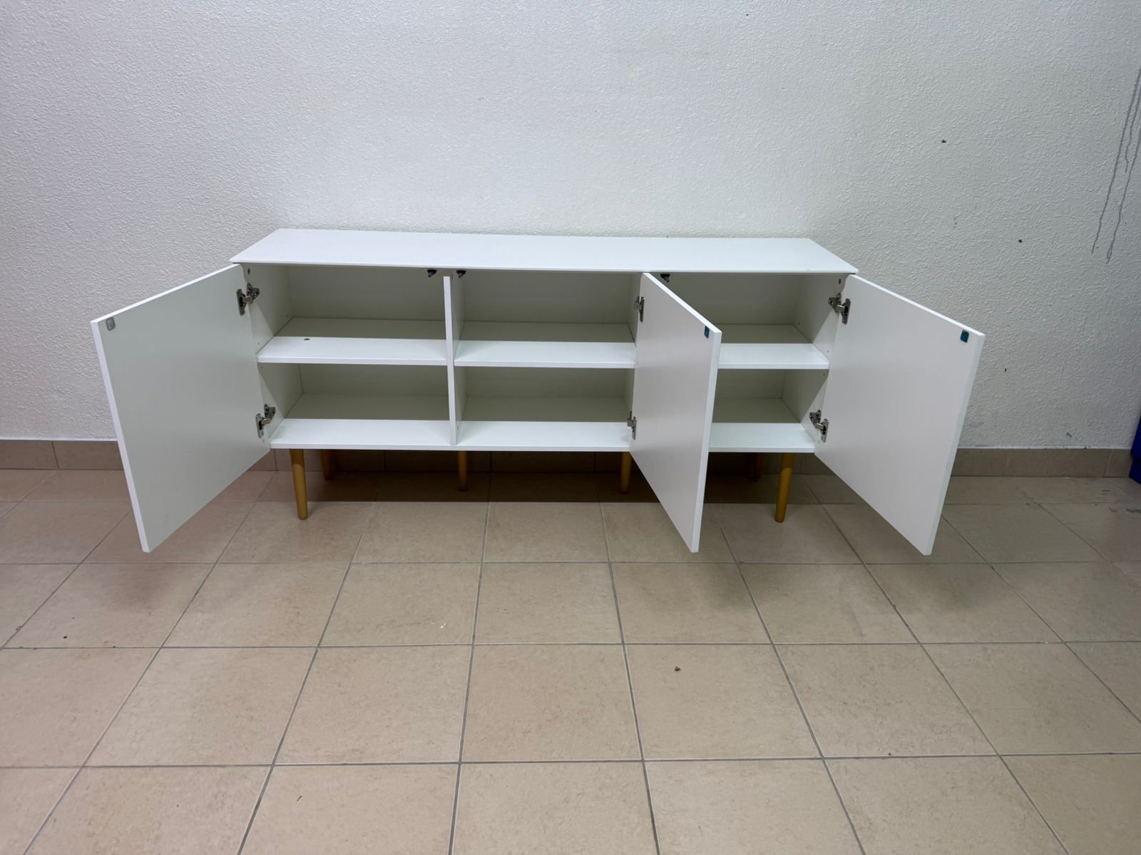 A modern white buffet cabinet featuring a simple design and light-colored wooden legs. - Image 10