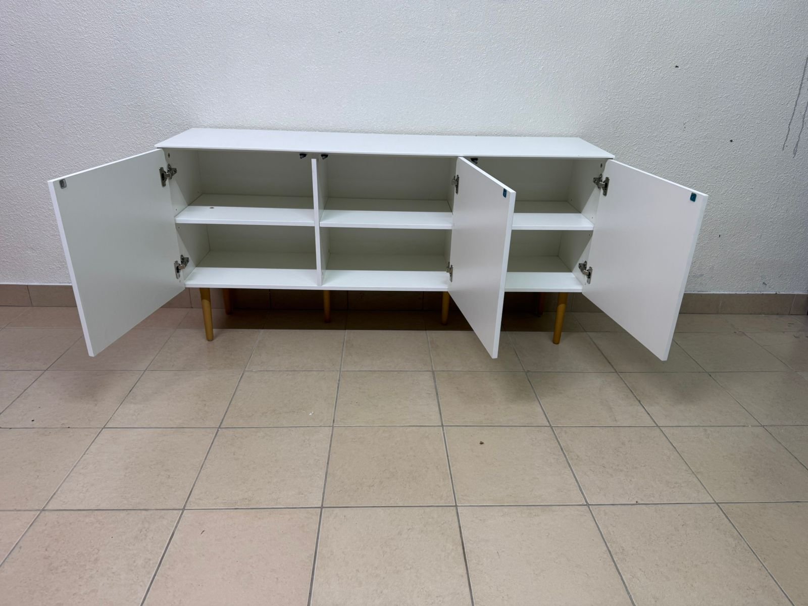 A modern white buffet cabinet featuring a simple design and light-colored wooden legs. - Image 4