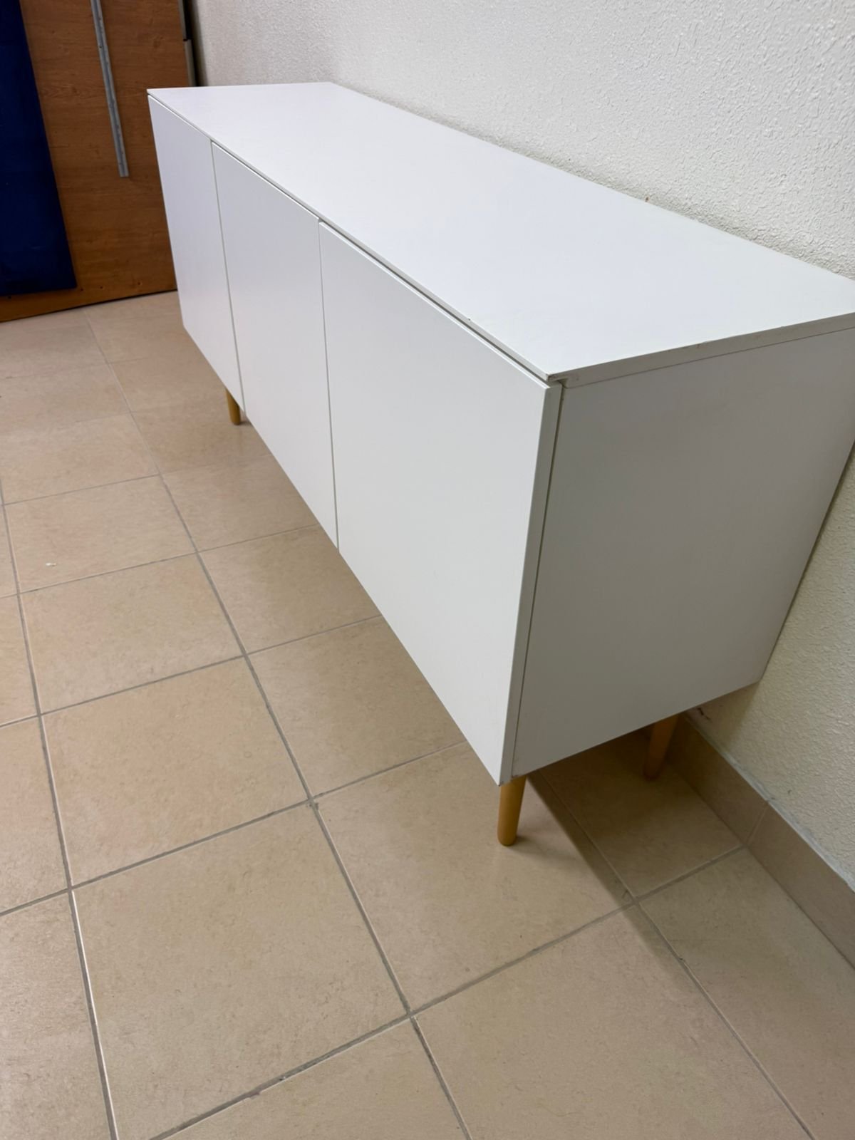 A modern white buffet cabinet featuring a simple design and light-colored wooden legs. - Image 5