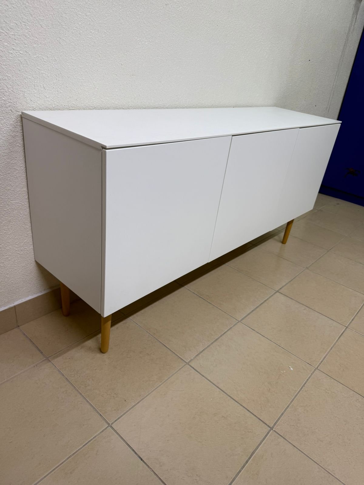 A modern white buffet cabinet featuring a simple design and light-colored wooden legs. - Image 2