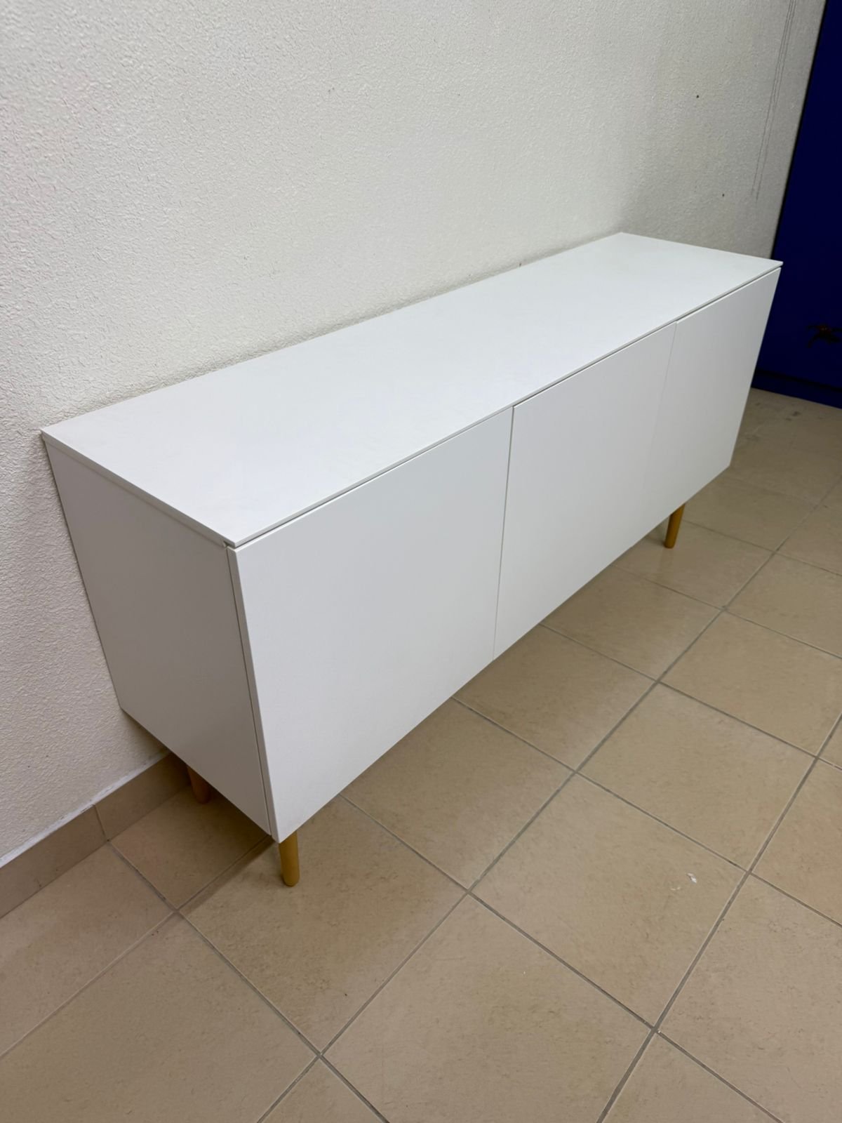 A modern white buffet cabinet featuring a simple design and light-colored wooden legs. - Image 3