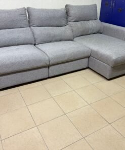 A sofa bed from IKEA, in gray, with a design that combines three seats and a long armrest.