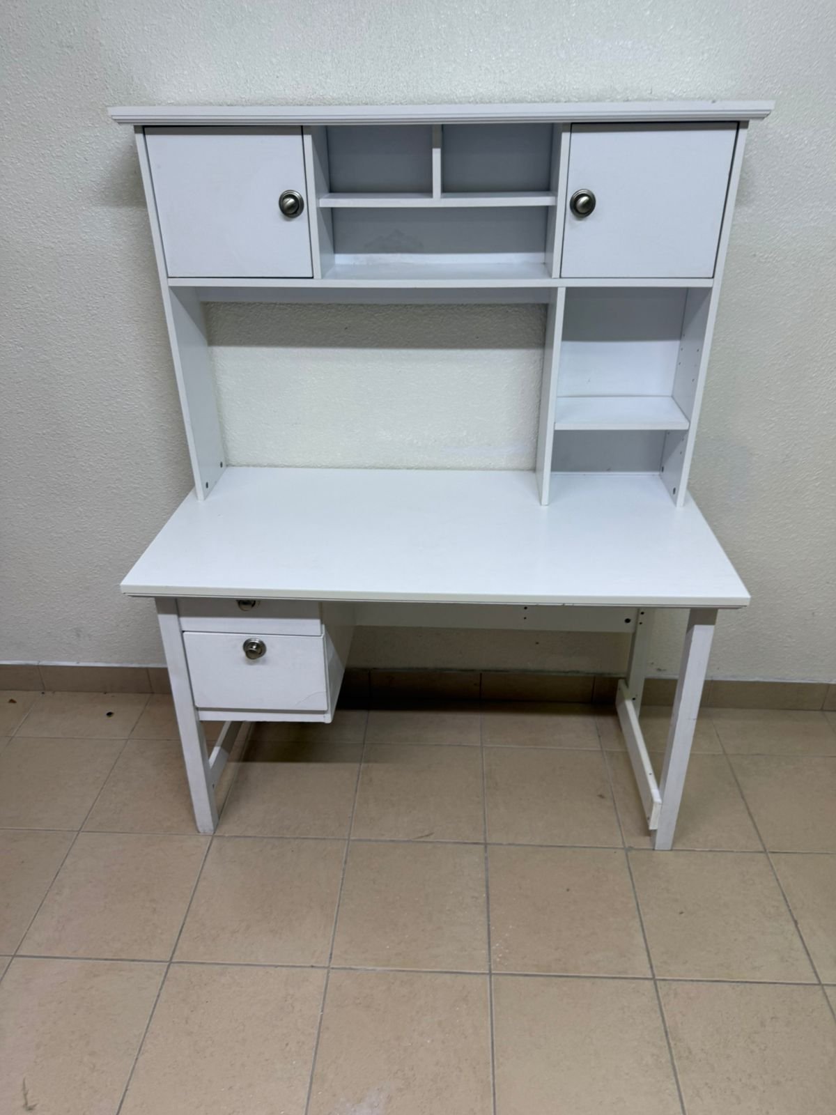 This Country study desk with a top cabinet in white features a matte finish and practical storage shelves.