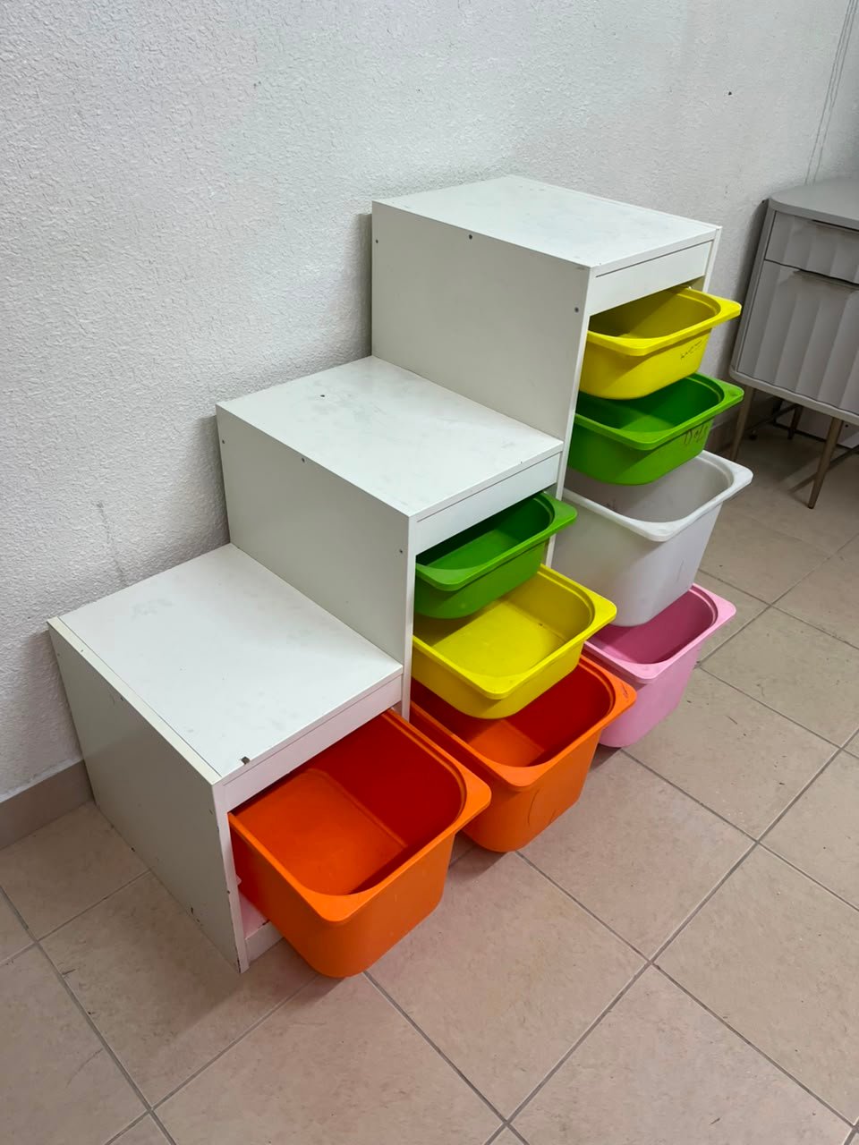 This TROFAST from IKEA is a children's toy storage unit designed with tiered levels for easy access, and features a white wooden frame. - Image 7