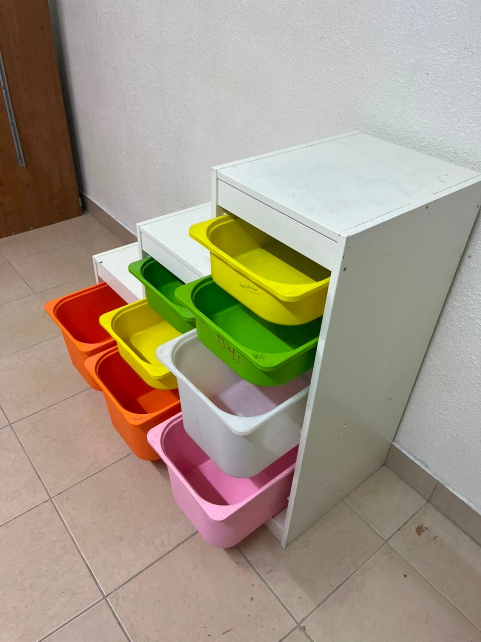 This TROFAST from IKEA is a children's toy storage unit designed with tiered levels for easy access, and features a white wooden frame. - Image 9