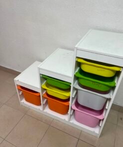 This TROFAST from IKEA is a children's toy storage unit designed with tiered levels for easy access, and features a white wooden frame.