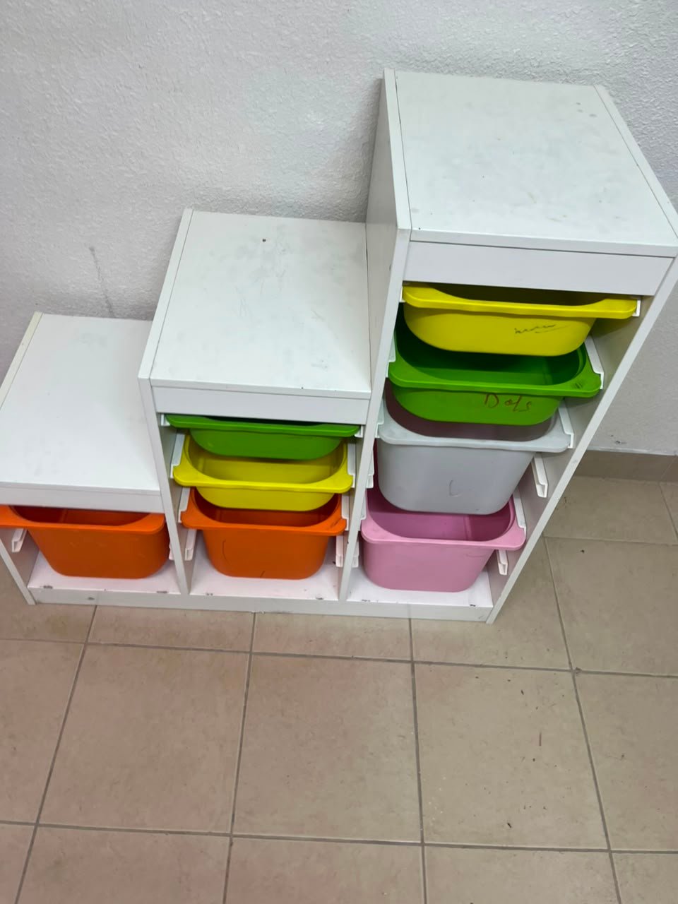 This TROFAST from IKEA is a children's toy storage unit designed with tiered levels for easy access, and features a white wooden frame. - Image 6