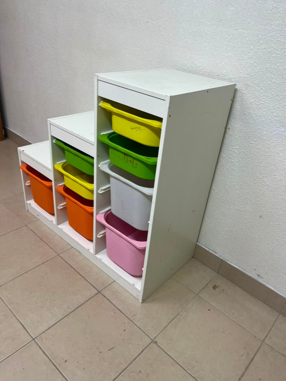 This TROFAST from IKEA is a children's toy storage unit designed with tiered levels for easy access, and features a white wooden frame. - Image 8