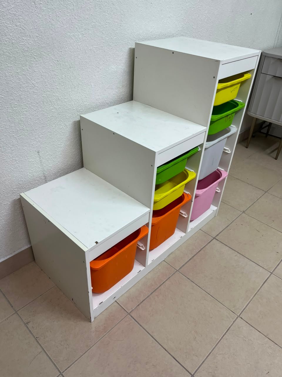 This TROFAST from IKEA is a children's toy storage unit designed with tiered levels for easy access, and features a white wooden frame. - Image 3
