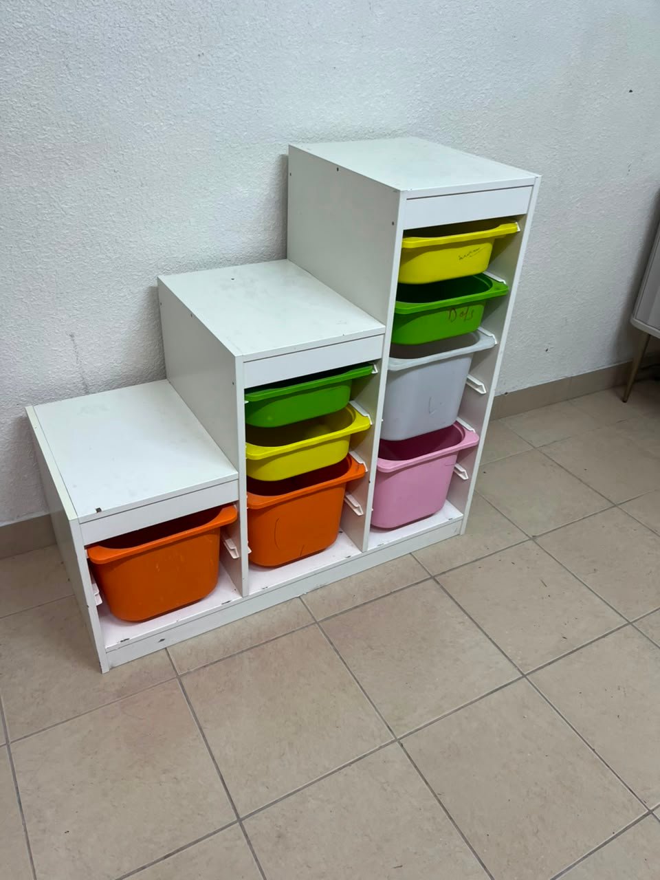 This TROFAST from IKEA is a children's toy storage unit designed with tiered levels for easy access, and features a white wooden frame. - Image 4