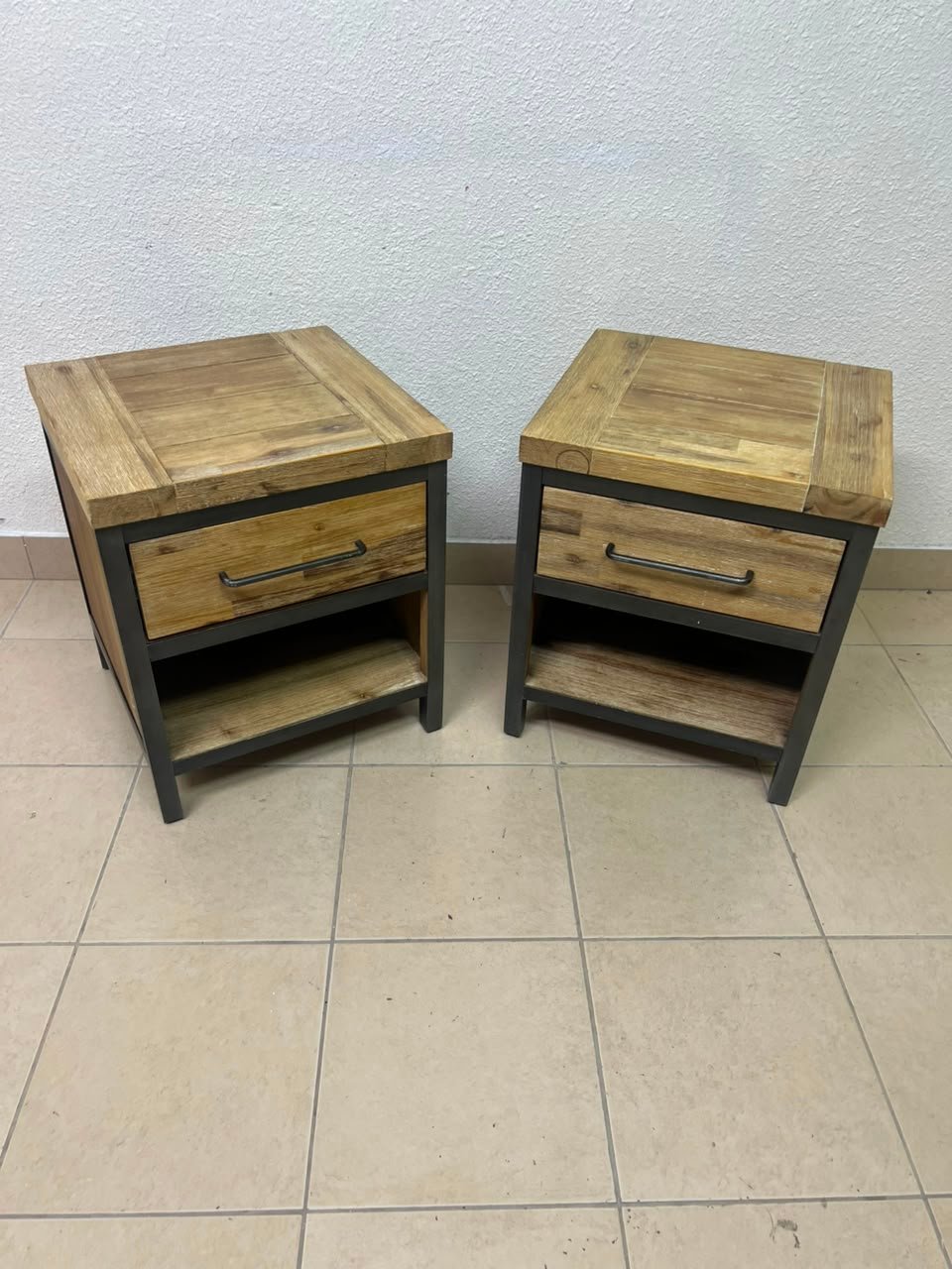 Bedside table with a sturdy dark gray metal frame and natural wood top and drawers