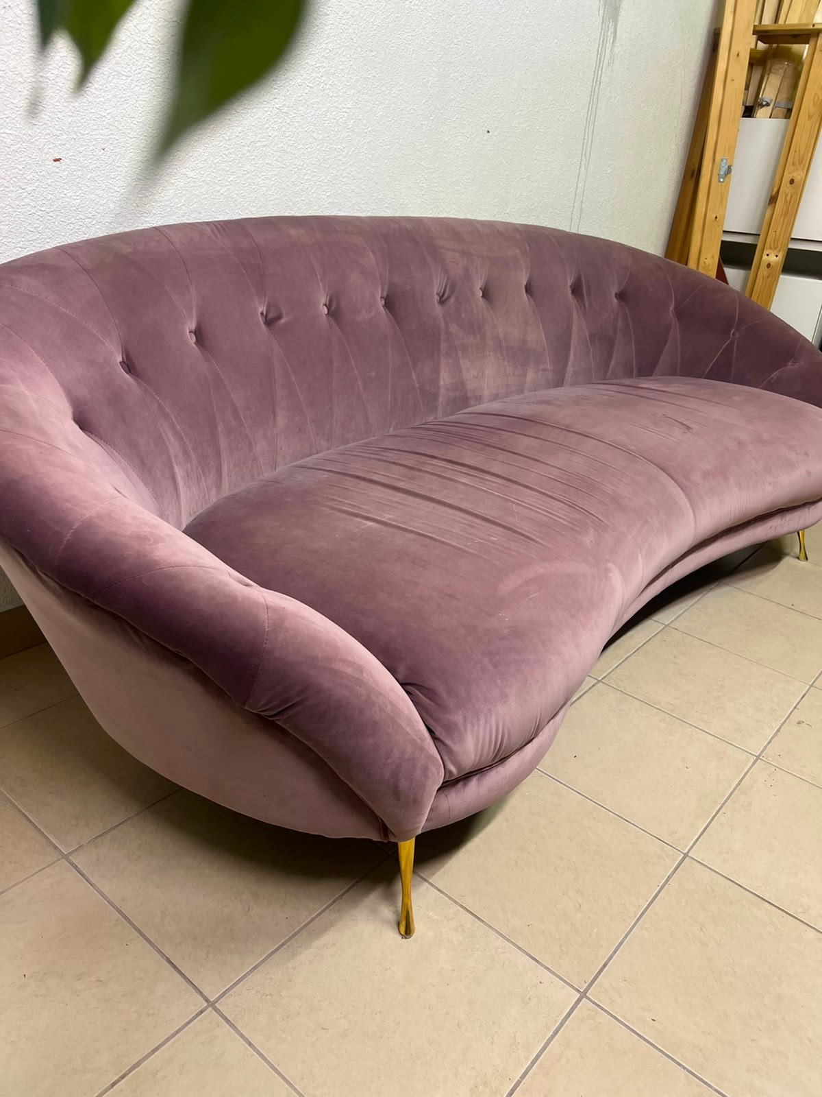 A luxurious 3-seater velvet sofa with a curved design, back upholstery buttons, and gold metal pointed legs.