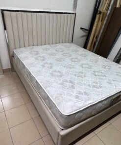 The beige upholstered Irony bed features a headboard with vertical lines and a shiny silver frame.