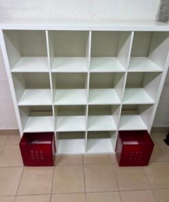 IKEA Kallax white shelving unit measuring 147×147 cm with red metal drawer inserts.