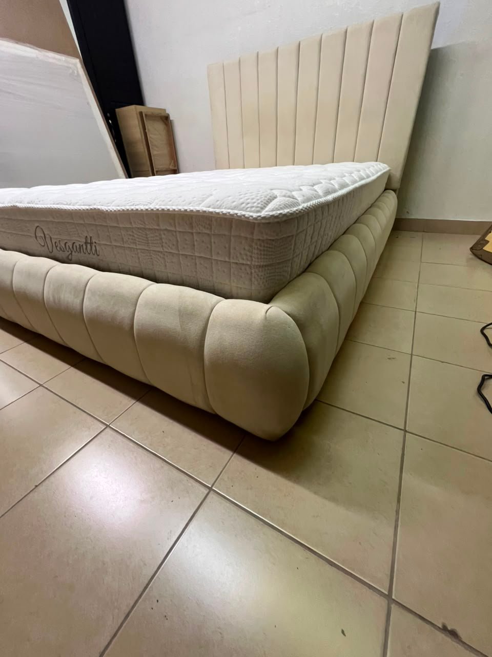 The cream-colored upholstered bed features a stylish and comfortable headboard. - Image 14