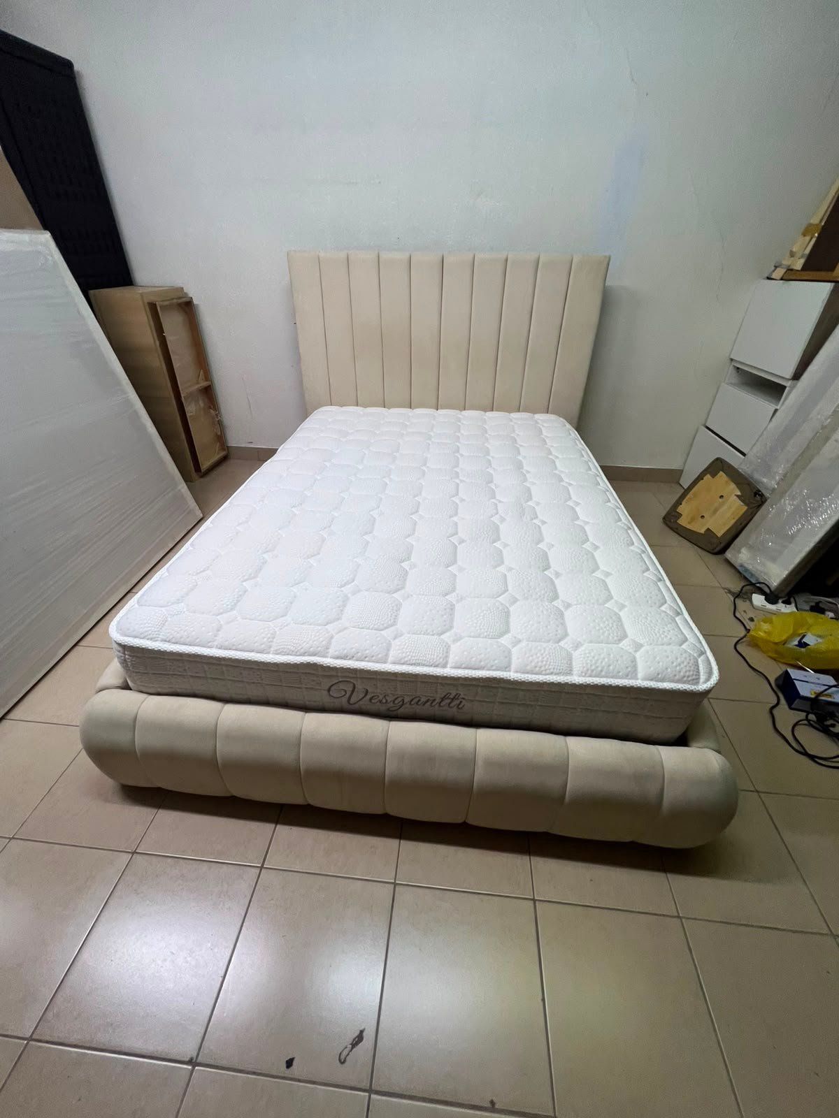 The cream-colored upholstered bed features a stylish and comfortable headboard. - Image 4