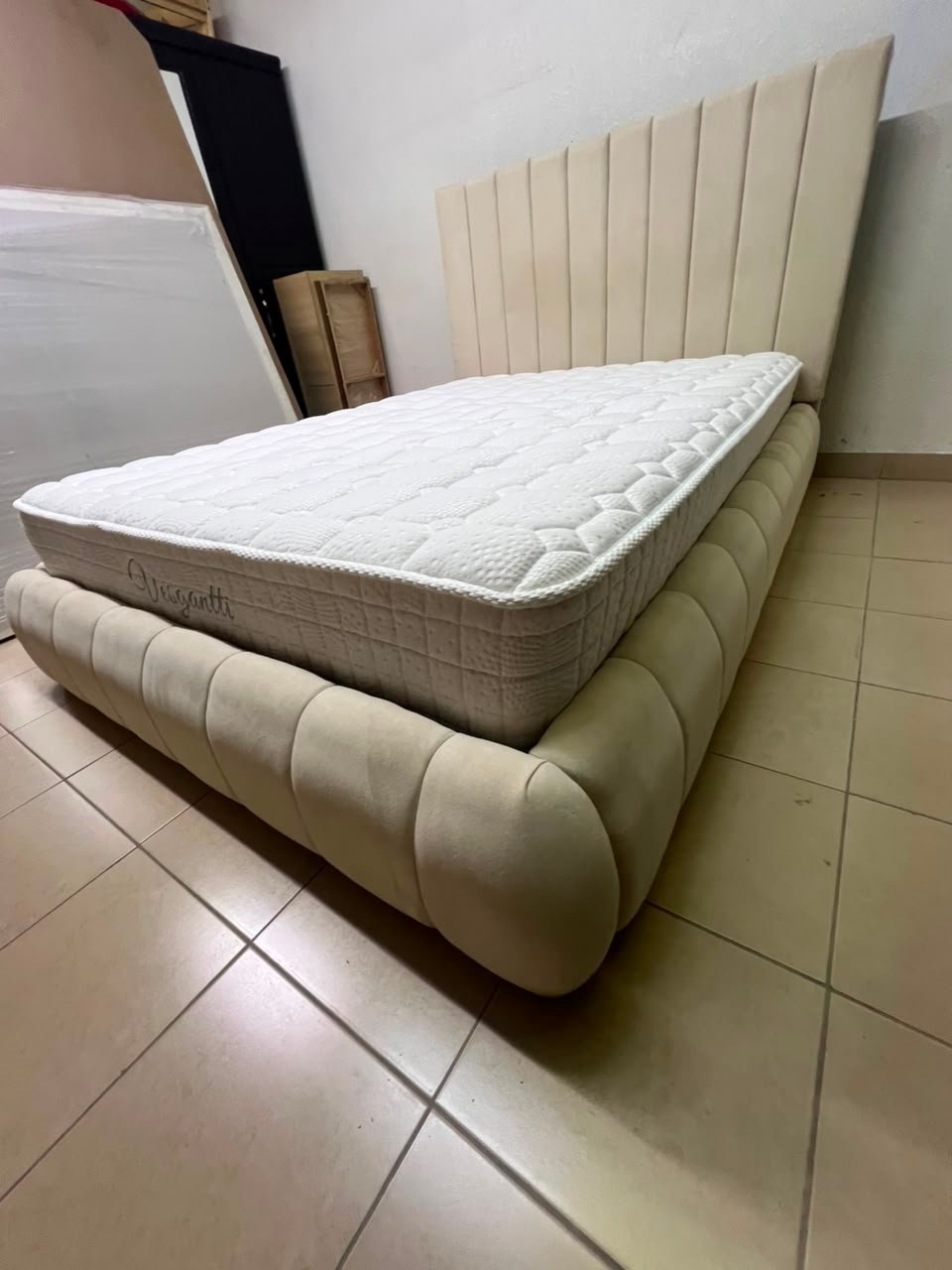 The cream-colored upholstered bed features a stylish and comfortable headboard. - Image 15