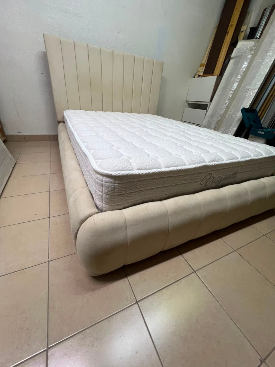 The cream-colored upholstered bed features a stylish and comfortable headboard. - Image 10