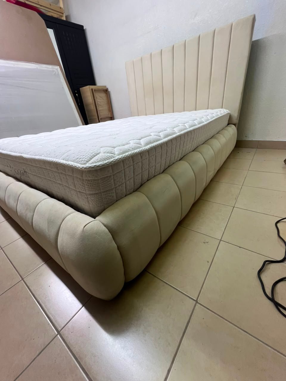 The cream-colored upholstered bed features a stylish and comfortable headboard. - Image 11