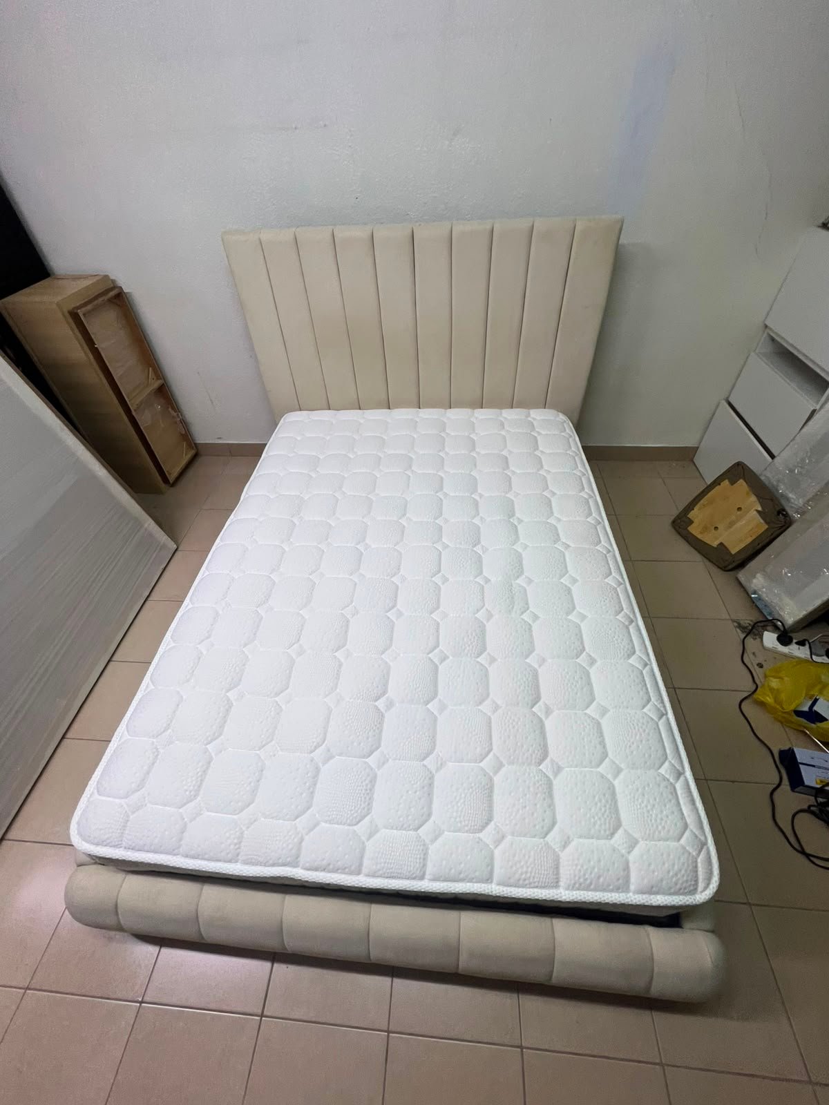 The cream-colored upholstered bed features a stylish and comfortable headboard. - Image 3