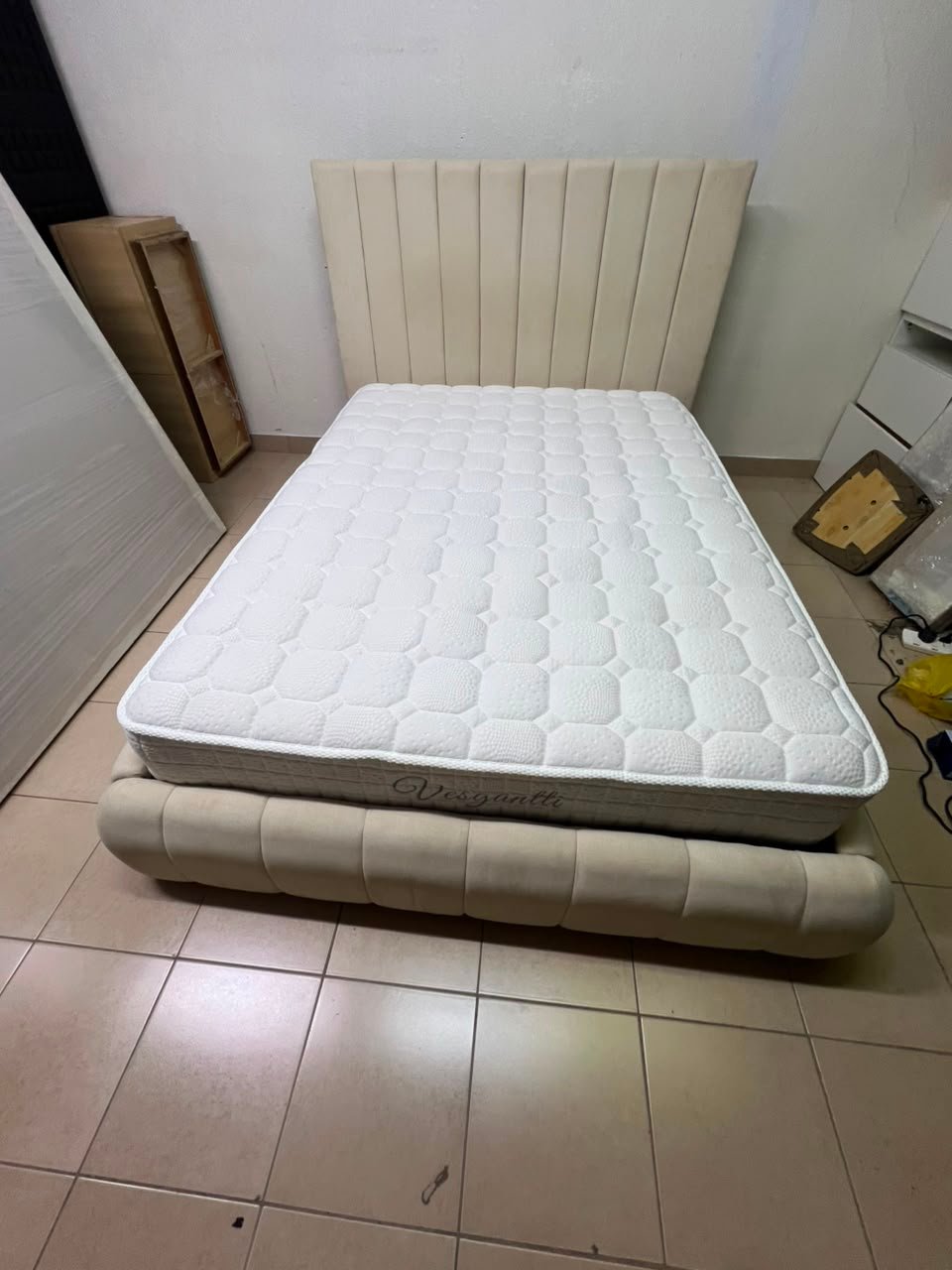 The cream-colored upholstered bed features a stylish and comfortable headboard. - Image 12